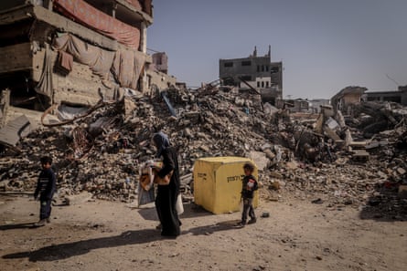 Mother and two children walking past a yellow block marking the safe zone