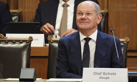 Olaf Scholz smiling during questioning.