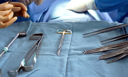 Surgical tools on a tray and surgeons in the background.