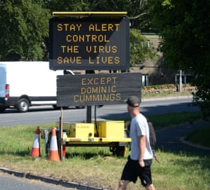 A road sign that says ‘Stay Alert, Control the Virus, Save Lives’ alongside an additional sign, added by members of the public, stating ‘Except Dominic Cummings’ in Bridport, England.