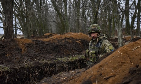 Seorang prajurit Ukraina berjalan di parit di posisi garis depan di lokasi yang dirahasiakan di timur Ukraina