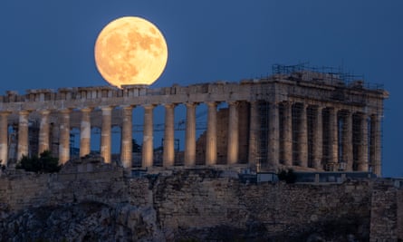 The Parthenon in Athens with a full moon in the background.