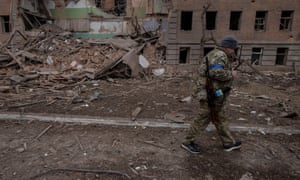 Russia-Ukraine war latest news: Kyiv rejects Moscow’s deadline for Mariupol surrender; Biden to visit Poland – live | World news 5 A Ukrainian service member walks past a destroyed building in the town of Okhtyrka in the Sumy region.