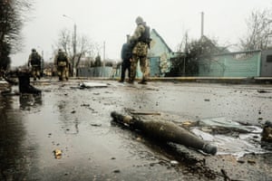 Ukrainian soldiers inspect the wreckage of a destroyed Russian armoured column on a road in Bucha, a suburb just north of the Capital, Kyiv.