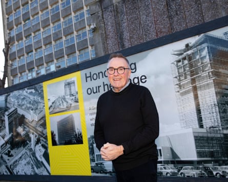 Tudor Evans next to a billboard in front a concrete tower