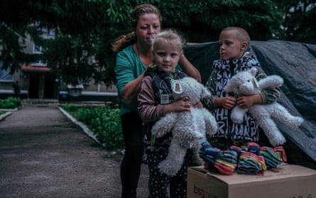 Inna, 31, and her children - Rostyslav, 6, and Snizhana, 3, waiting for the humanitarian aid and her husband, who is serving and recently was wounded.