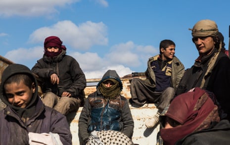 Young men and boys who fled heavy fighting in the city of Baghuz, wait in the back of a truck to be transported to the al-Hol refugee camp which houses suspected Isis families, 11 February 2019.