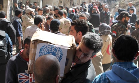 Residents of Syria’s Yarmuk refugee camp, south of Damascus, receive food parcels from the UN Relief and Works Agency.