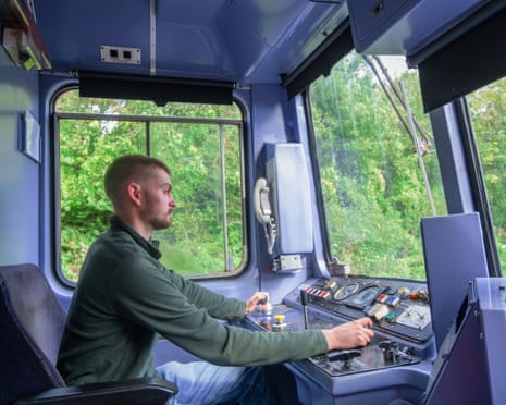 A young man operates the controls of a commuter train on the Tarka Valley railway in Devon.