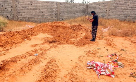 A member of security forces affiliated with the Libyan government of national accord stands at the reported site of a mass grave in the town of Tarhuna.