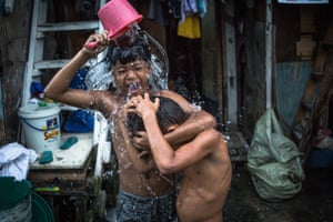 Children take a bath in a slum area of Manila, Philippines