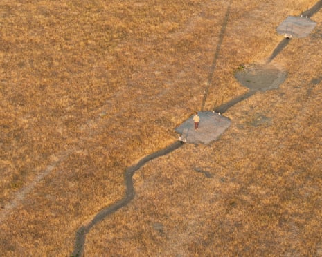 An aerial view as a person walks across dried ponds in Richmond Park, London, England.