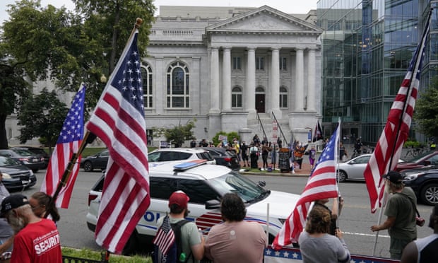 people wave flags outside building in DC
