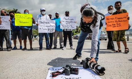 A photojournalist places his camera on the ground in protest of the murder of his colleague Cardoso in Acapulco.