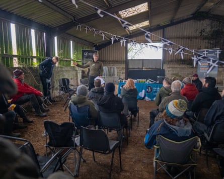 Cheryl Marriott speaks to a dozen or so listeners on seats in a barn