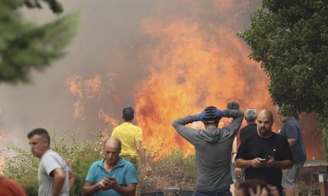 People stand near a forest fire in Añón de Moncayo, Spain, on Saturday