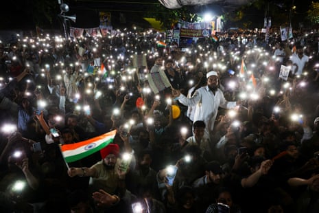A crowd wave their phone lights