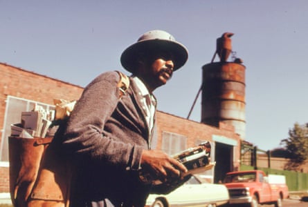 A postal worker walks as he delivers mail