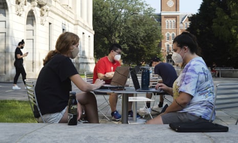Students sit outside Thompson Library during the first day of fall classes at Ohio State University in Columbus, Ohio, in August 2020.