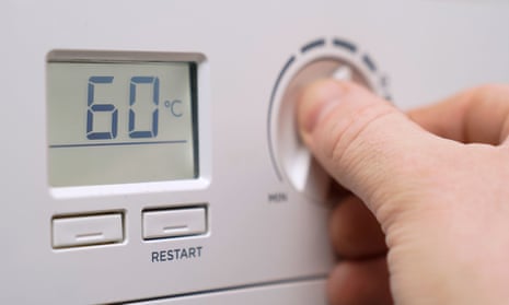 A homeowner turning down the temperature of a gas boiler
