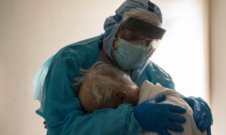 Doctor in full PPE hugs a patient