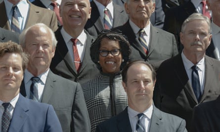 woman smiling in a crowd of men in suits