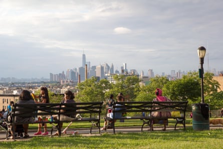 People sit in Sunset Park park overlooking the New York city skyline