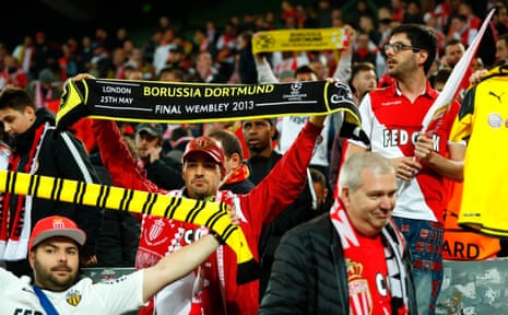 Monaco supporters with Borussia scarves react in a show of solidarity for their hosts after the match was postponed.