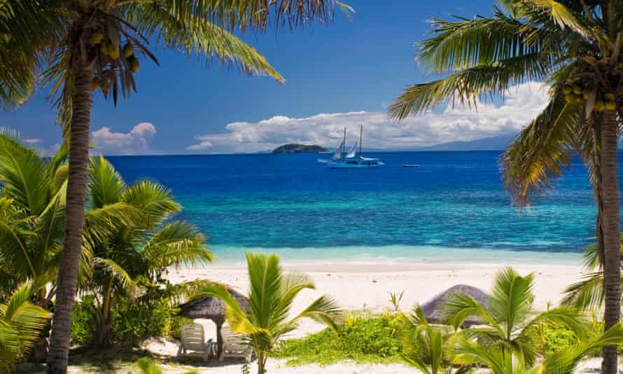 Sailboat seen through palm trees, Mamanuca Group islands, Fiji