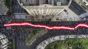 Demonstrators carry a huge flag at the protest march against Merino’s new government on 14 November