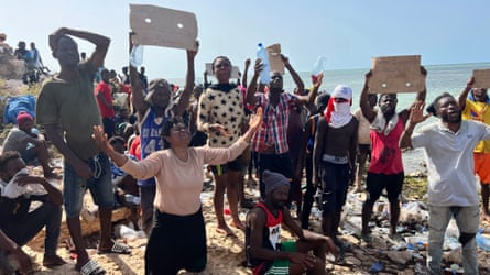A group of Africans hold placards with slogans such as 'Tunisian government is killing us slowly'