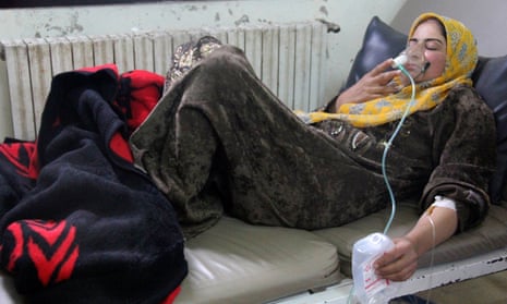 A woman, affected by what activists say was a gas attack, breathes through an oxygen mask inside a field hospital in Hama province in April 2014. 