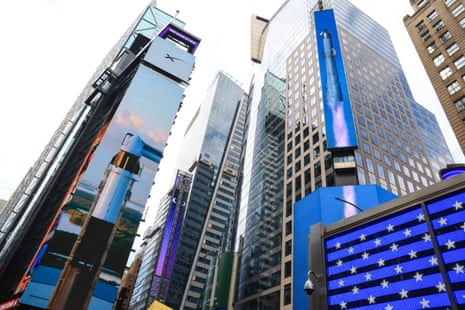 Images of SpaceX rockets are displayed on screens in Times Square near the Nasdaq MarketSite today