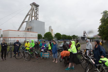 A small group of people with bicycles and a sign in French which translates as ‘water convoy’.