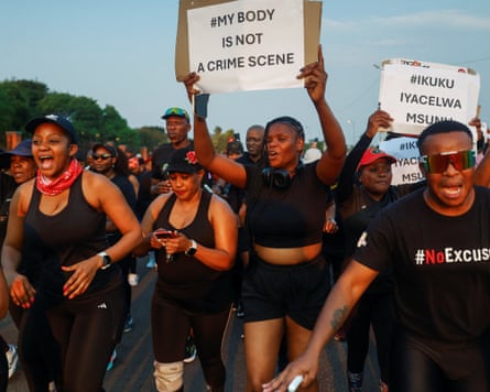 Participants carry placards during a memorial run held in honour of Elizabeth Tsontso Moselakgomo, one of several women killed in a series of murders near Johannesburg