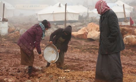 Displaced Syrians clear an area to set up tents after fleeing violence in Maarat al-Numan earlier this month.