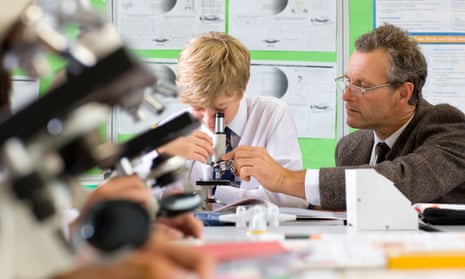 Student and teacher with microscope in science class