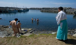 Shinto priest Sadoharu Nagatomo guides a group of men in a purification ritual before entering the island of Okinoshima.