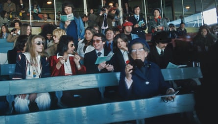 A group of people in racecourse stands, chatting together