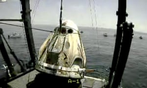 The SpaceX capsule is lifted onto a ship