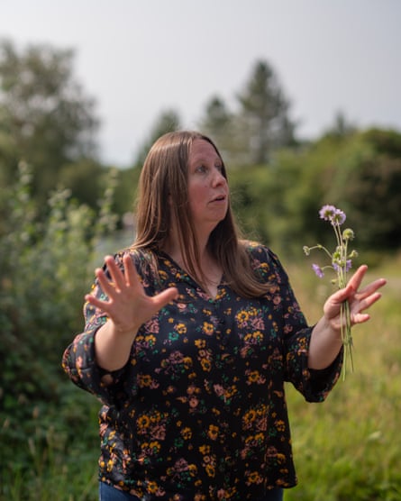 Rose with meadow behind and wildflowers in hand