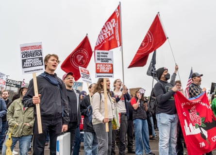people holding signs and flags at a protest