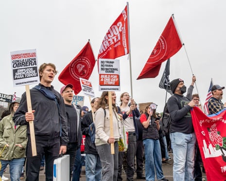a crowd of people holding flags and signs