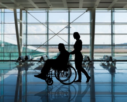 A person in a wheelchair being pushed through an airport