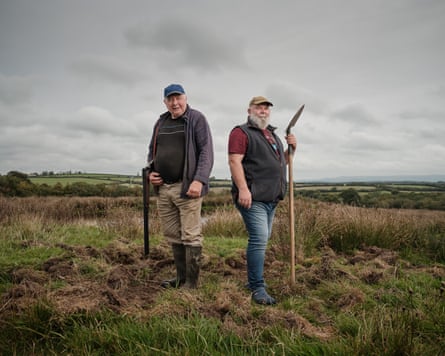 The two farmers - one with a shotgun cocked, the other with a spade.