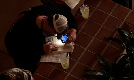 Gamblers study the racing form prior to the Breeders’ Cup juvenile turf sprint race at Del Mar Race Track in 2021. The prestigious meeting returns to the California track again this year.