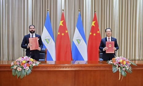 Representatives for Nicaragua and China display their jointly signed communique on the resumption of diplomatic relations 