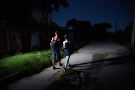 Children with backpacks on a dark street
