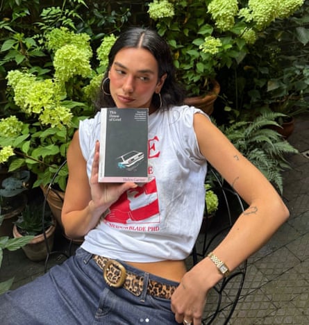 Dua Lipa poses with a copy of This House of Grief.