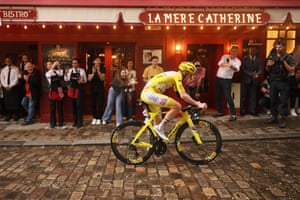 Yellow jersey holder Tadej Pogacar rides through the Place de Tertre in the Montmartre district.